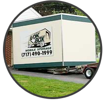 A Lok Box container on a delivery trailer beside a home